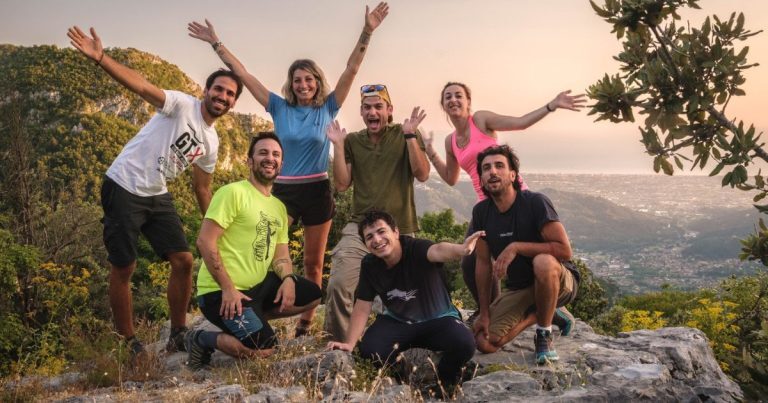 Corsisti della Guida ambientale in posa su una roccia al tramonto