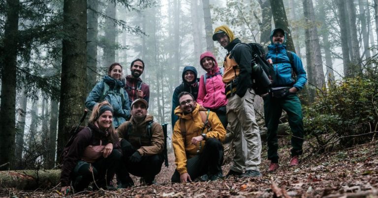 Gruppo di corsisti nel bosco nella nebbia durante un'uscita didattica